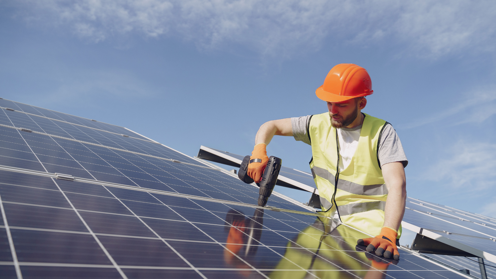 Image de fond : artisan sur un panneau photovoltaïque